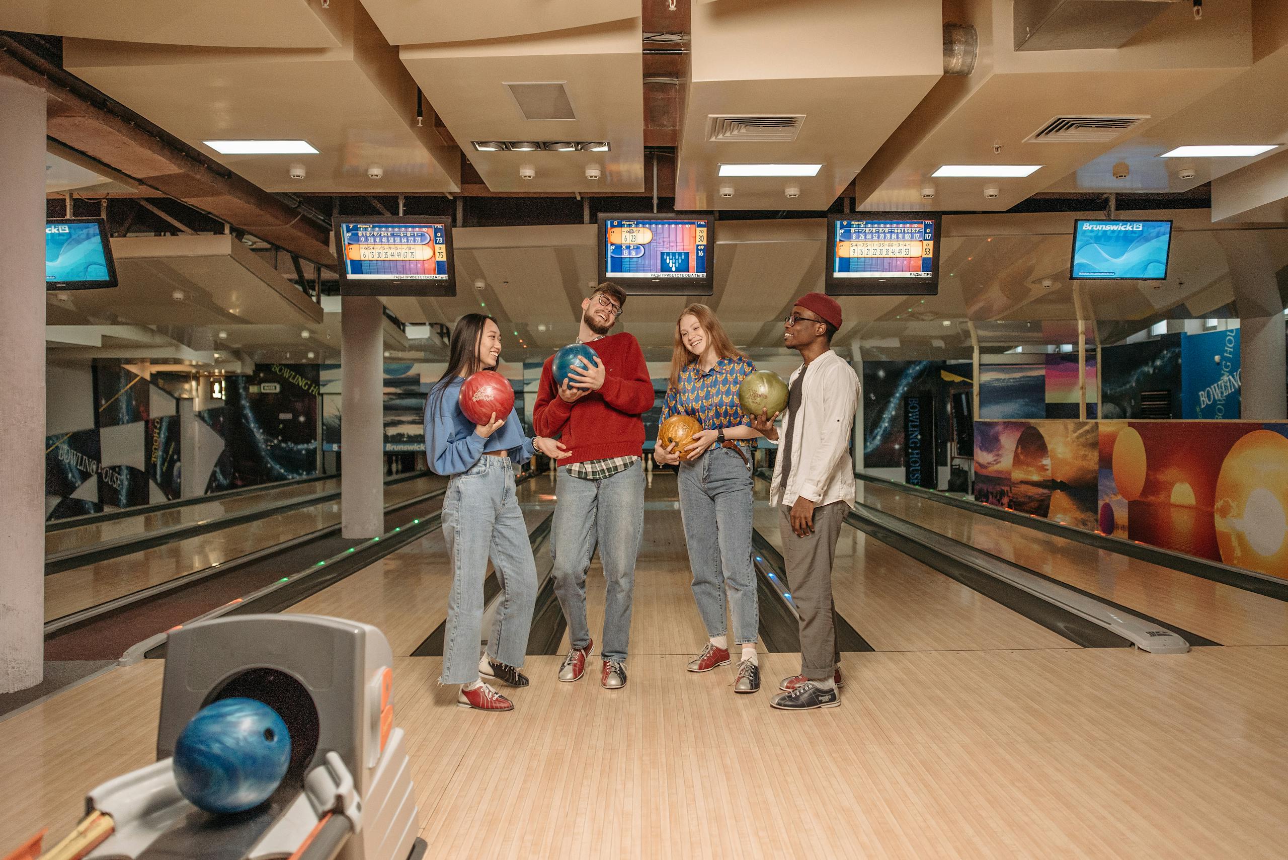 A group of young friends having fun bowling in an indoor alley, enjoying leisure time together.